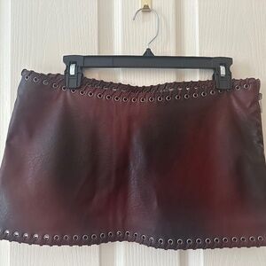 Burgundy leather mini skirt with grommet trim